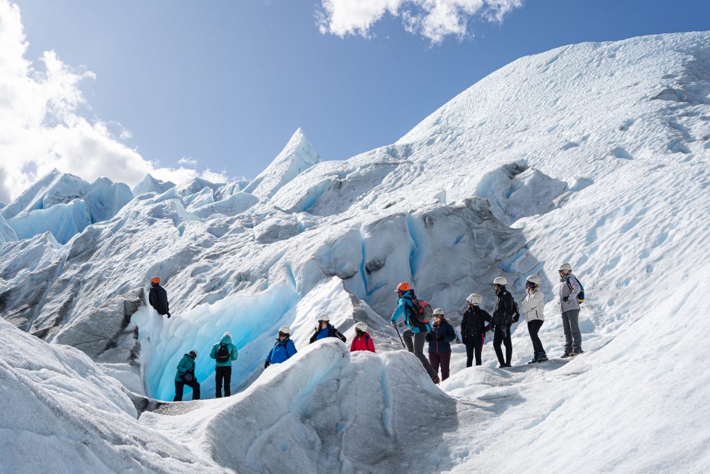Barco catamarán navegando frente a la pared de hielo en el Safari Náutico